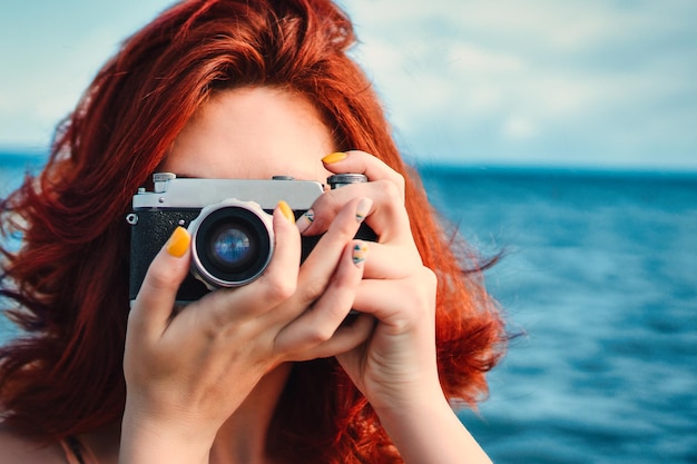 Foto fotógrafa de viajes de mujer pelirroja tomando fotos en el fondo del mar