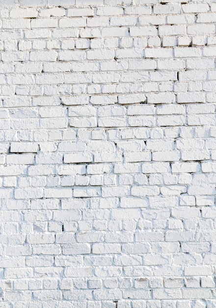 Fotografado em close da parede de um prédio antigo feito de tijolos pintados de branco