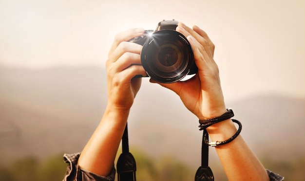 Fotografando a paisagem, close-up de um jovem fotógrafo asiático segurando a câmera