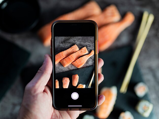 Fotografando comida. Mãos tirando fotos de deliciosa comida asiática