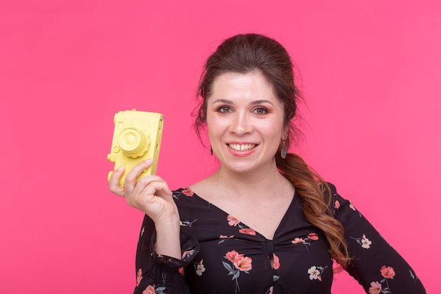 Fotografando, glamour e conceito vintage - jovem mulher com câmera retro sorrindo