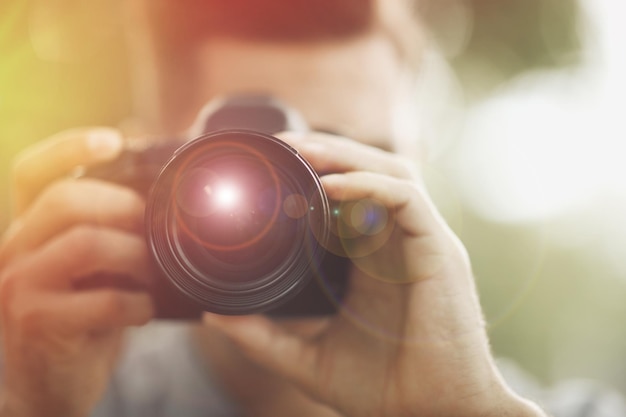 Foto fotografen, die mit einer professionellen kamera im freien fotografieren, konzentrieren sich auf das objektiv