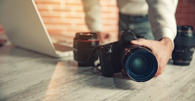 Fotografenhandkamera, die im Schreibtisch arbeitet