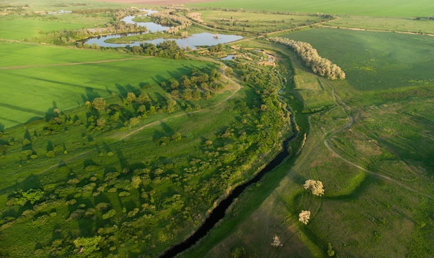 Fotografía aérea de campos verdes y río en la distancia.