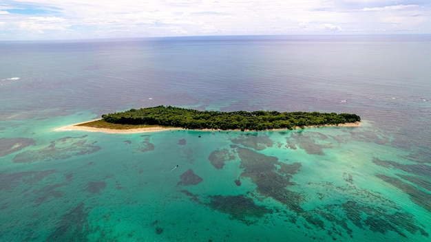 Fotografía aérea de una isla verde rodeada de aguas tranquilas del océano en Bocas del Toro, Panamá