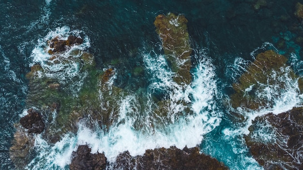 Fotografía aérea de olas rompiendo en rocas