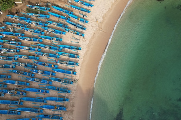 Foto fotografía aérea de una playa tropical de arena blanca con barcos de pesca azules agua turquesa
