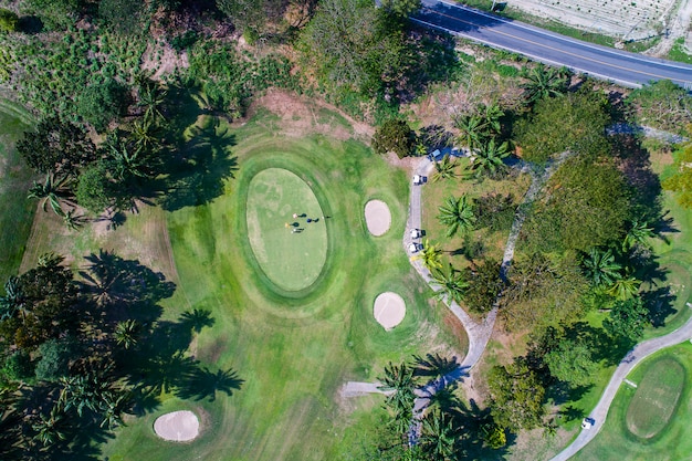 Fotografía aérea vista de bosque y campo de golf con lago. Golf y club deportivo.