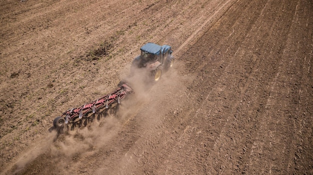 Fotografía aérea de la vista superior del campo de arado del tractor con drone