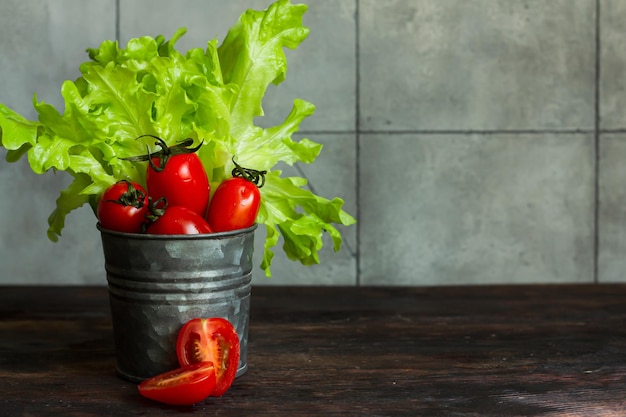 Fotografia alimentar de legumes tomate cereja e alface em um copo de metal