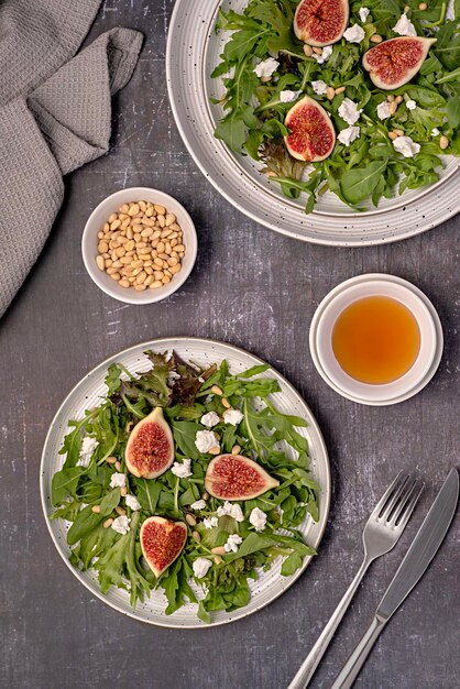 Fotografia alimentar de salada, queijo de cabra, figo, folha de feta, alface, rúcula, pinhão, mel