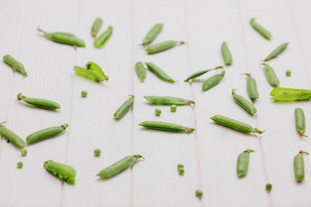 Fotografía de alimentos. Guisantes esparcidos sobre una pizarra blanca