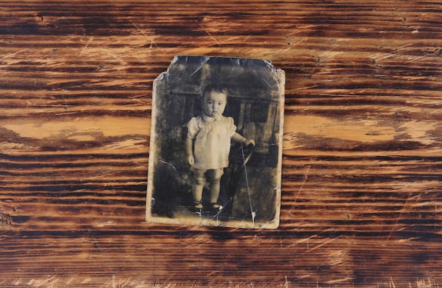 fotografía antigua de un niño aislado en un fondo de madera