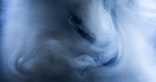Foto fotografía artística de un humo azul blanquecino en patrones giratorios