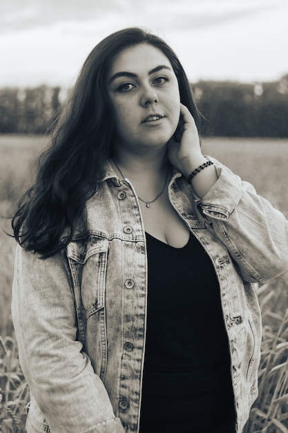 Fotografía en blanco y negro de una joven adulta en un campo de trigo