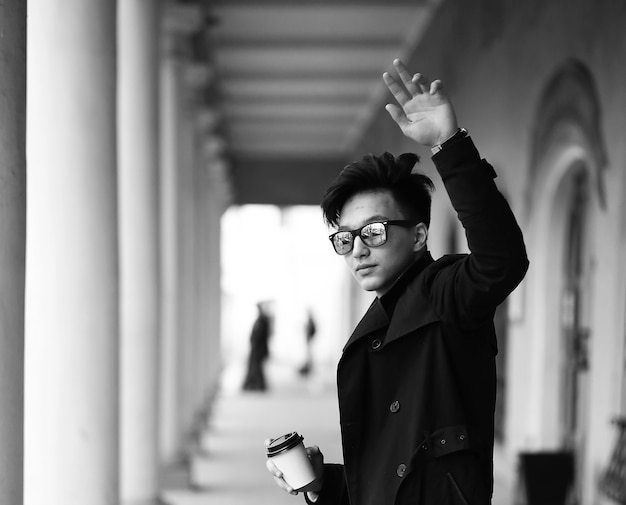 Fotografía en blanco y negro de un joven asiático al aire libre posando en la cámara