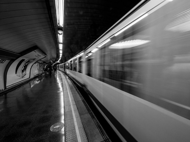 Fotografía en blanco y negro del tren subterráneo saliendo de la estación