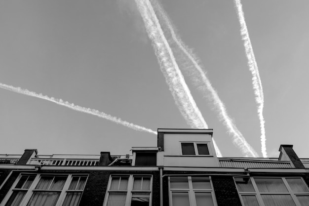 Foto fotografia branca céu e casas com telhados e vestígios de jatos ou aviões holanda haia