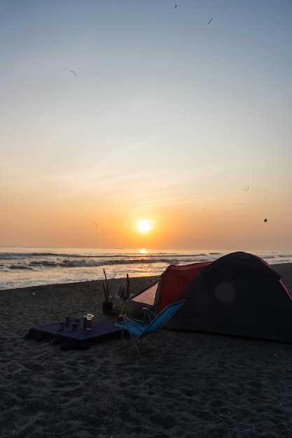 Fotografía de una carpa roja en la playa al atardecer por Yuri Ugarte Cespedes