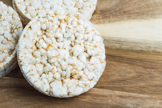 Fotografía cenital de tortas de arroz inflado saludables sobre tabla de madera.