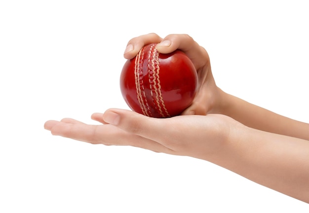 Fotografía de cerca de la mano de la jugadora de cricket a punto de lanzar la pelota de cricket de prueba roja