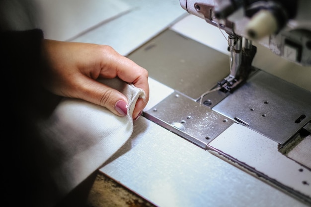 Fotografía de cerca de las manos femeninas usando una máquina de coser