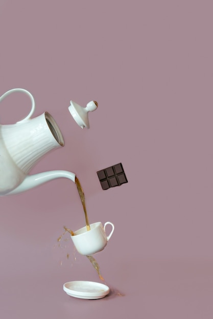 Una fotografía de cerca de un té con una tetera y una taza. Café y té, chocolate, levitación de alimentos.