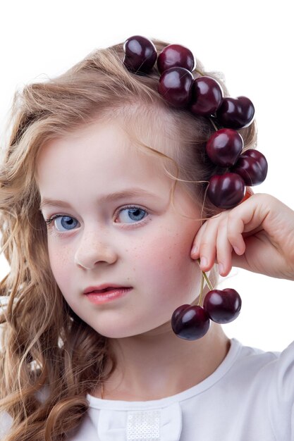 Foto fotografía de una chica de ojos azules con cerezas en la cabeza