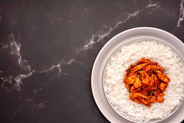 Fotografía de comida en blanco de arroz con pollo.