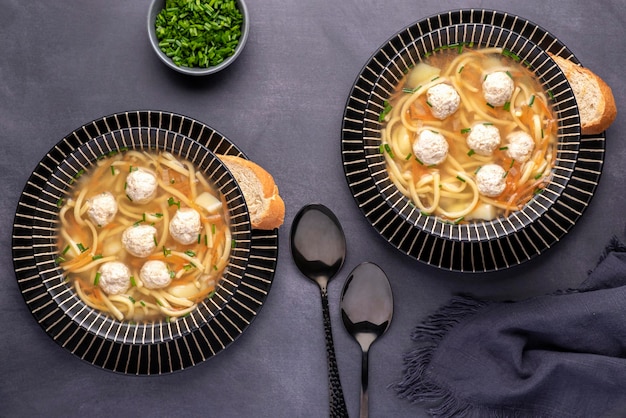 Fotografía de comida de sopa con albóndigas y fideos.