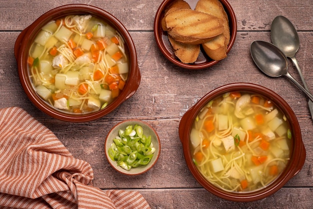 Fotografía de comida de sopa con fideos, pollo, patata y zanahoria.