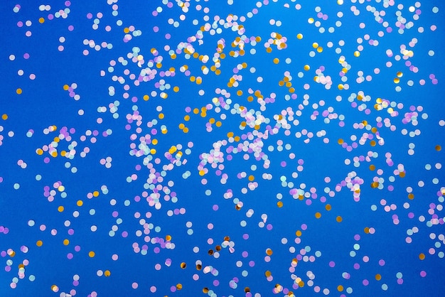 Foto fotografía completa de confeti sobre un fondo azul