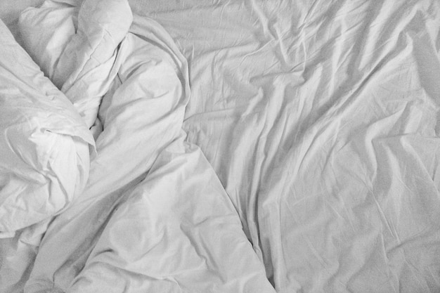 Fotografia completa de um lençol arrugado na cama.