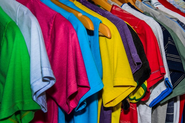 Fotografía completa de ropa de varios colores colgada en el estante de la tienda