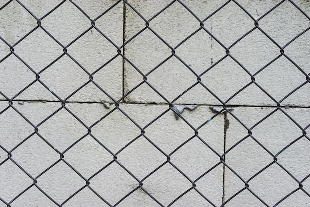 Fotografía completa de la valla de enchaines contra una pared de hormigón