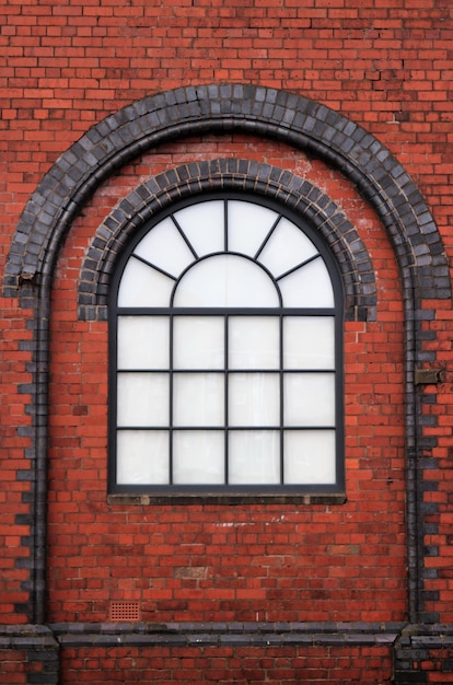 Foto fotografía completa de una ventana arqueada en una pared de ladrillo