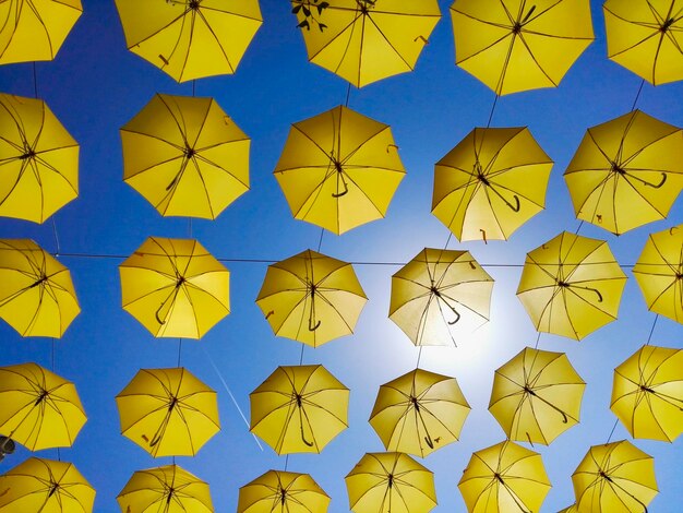 Foto fotografia de ângulo baixo de guarda-chuvas amarelos pendurados contra o céu