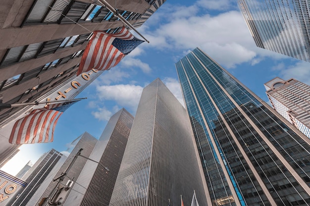 Foto fotografia de baixo ângulo de arranha-céus com bandeiras americanas em manhattan, nova york