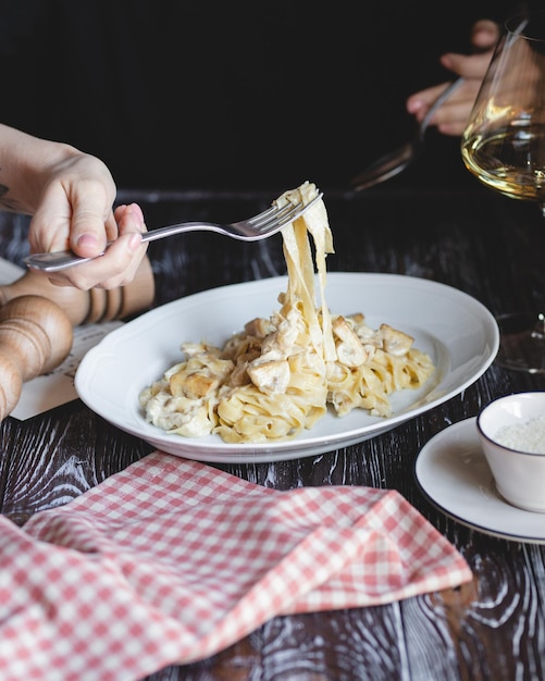 Fotografia de comida Massa italiana Mãos de menina com garfo e colher closeup