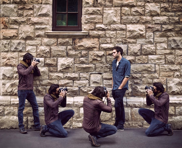 Fotografia de modelo e fotógrafo na cidade com homem ou paparazzi filmando na rua para a imprensa Projeto criativo e pessoa posando para cameraman filmando na parede ao ar livre com talento e moda