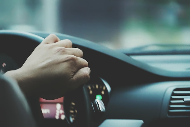 Fotografía detallada de un hombre cortado conduciendo un coche