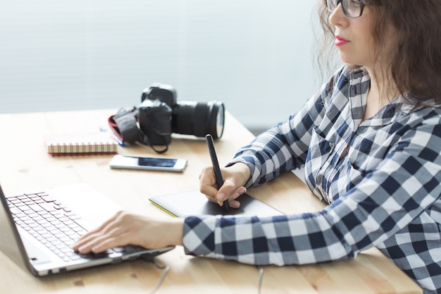 Fotografía, diseño web y concepto de arte gráfico: mujer con gafas usando un dispositivo de dibujo de bandeja de ratón