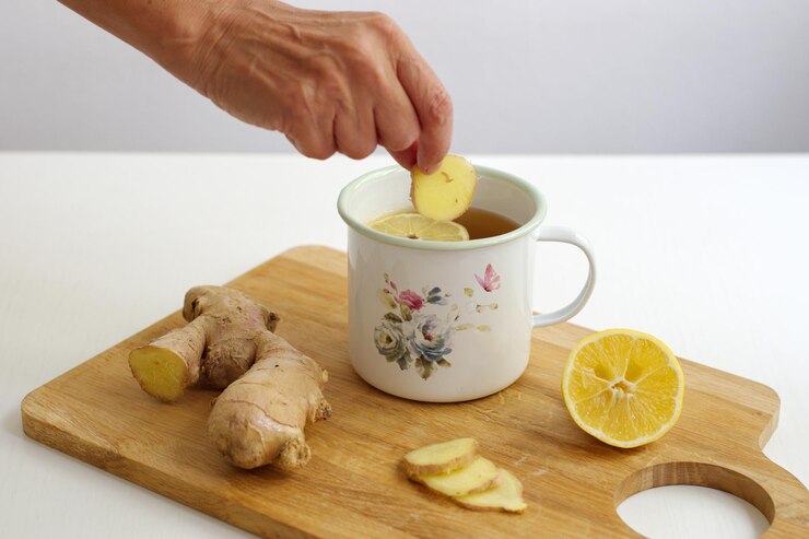 Foto fotografia em close de gengibre e chá de gengibre com limão no recipiente decorativo