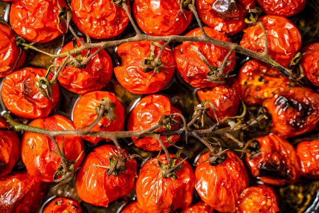 Fotografia em close de tomates de cereja vermelha assados com ervas de alho e azeitona Vista superior plana