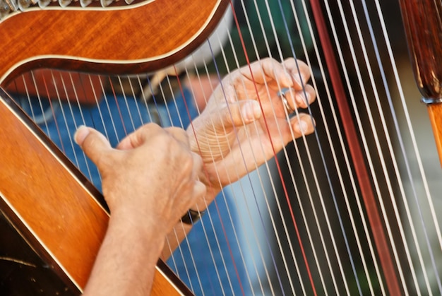 Foto fotografia em close-up de mãos de homem tocando harpa ao ar livre em santiago, chile, conceito de música e lazer