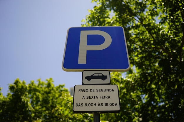 Fotografia em close-up de um sinal de estacionamento em fundo azul com texto em português em Lisboa, Portugal