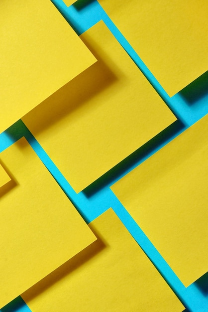 Fotografia em quadro completo de papel amarelo contra fundo azul