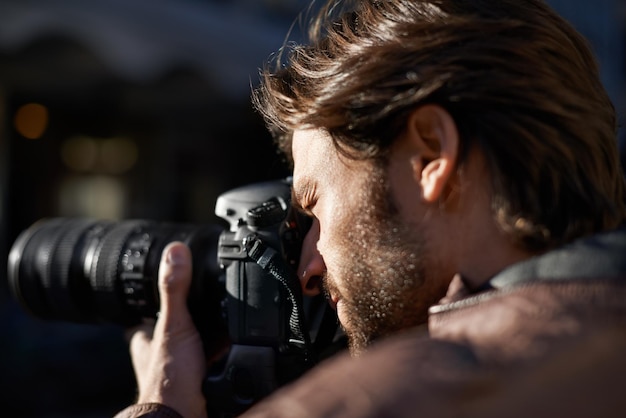 La fotografía es mi pasión Foto de un apuesto joven fotógrafo trabajando en la ciudad