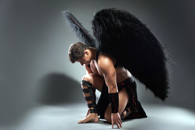 Fotografía de estudio de un hombre guapo posando como ángel caído