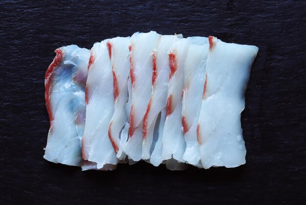 Fotografía de un filete de corte escaso como sashimi en fondo de pizarra para ilustraciones de alimentos